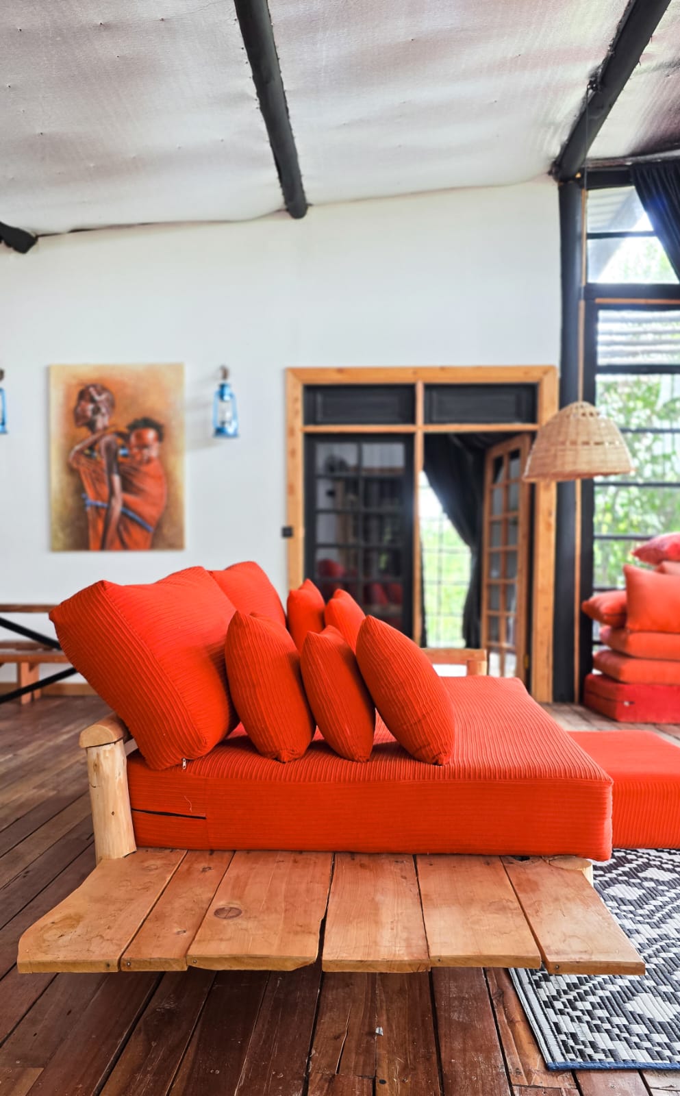 Bright orange lounge daybed with timber coffee table and rustic cabin decor.